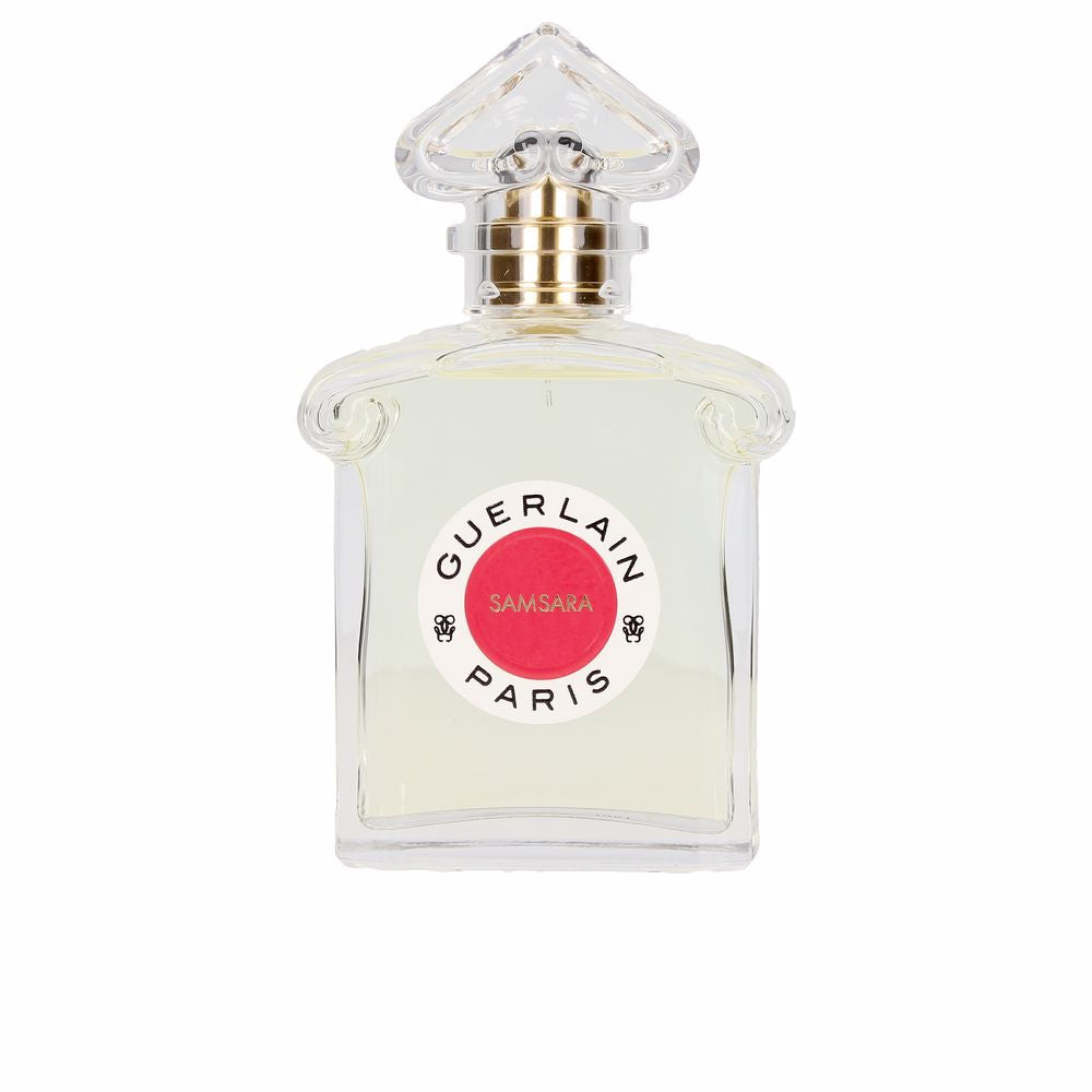 Clear glass perfume bottle with gold and red accents, heart-shaped cap and round label, Guerlain