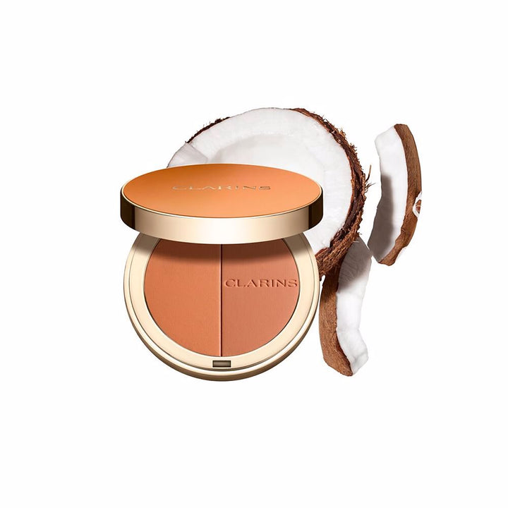 Clarins Round orange compact powder case with metallic rim, embossed brand name, minimalist metal/plastic finish