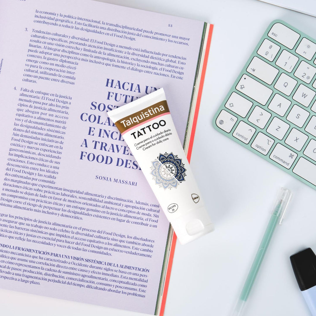 Jar of Talquistina tattoo care cream beside a tattoo sleeve, clean studio setting