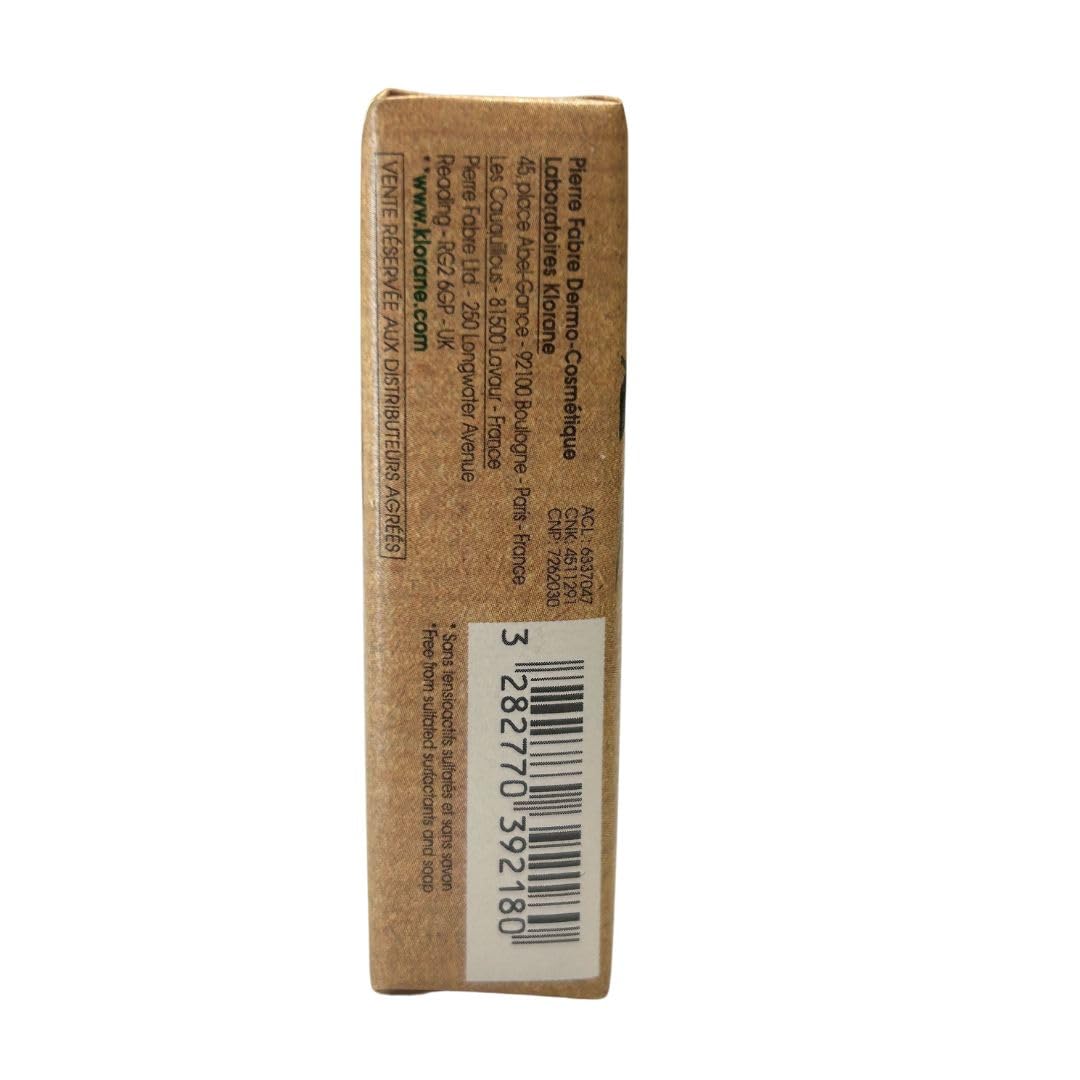 Klorane Brown rectangular shampoo bar in kraft paper with pink peony illustration, green accents, text labels, organic mark