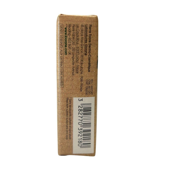 Klorane Brown rectangular shampoo bar in kraft paper with pink peony illustration, green accents, text labels, organic mark