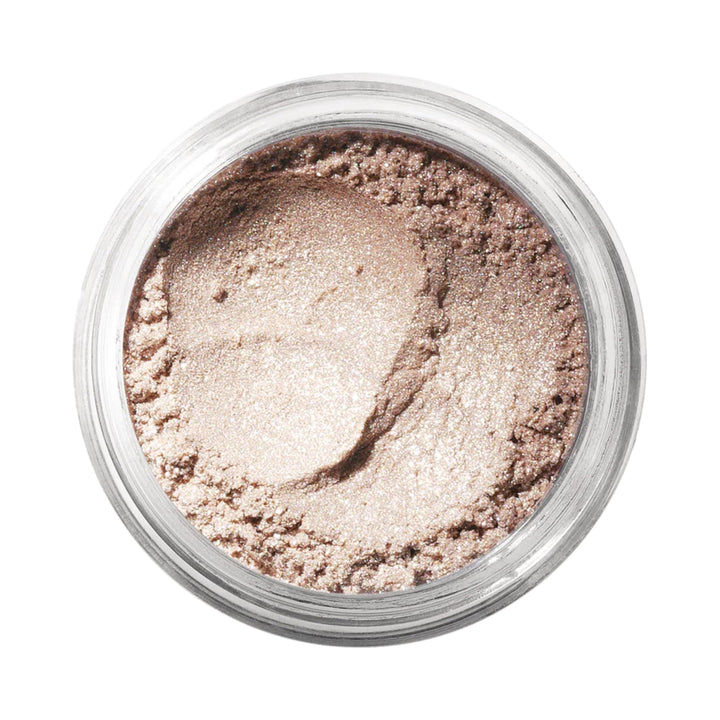 Small jar of loose mineral eyeshadow in warm nude shade, fine powder texture