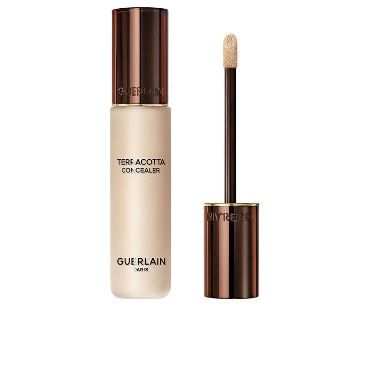 Guerlain Beige and dark brown liquid concealer in transparent cylindrical bottle with metallic cap and wand.