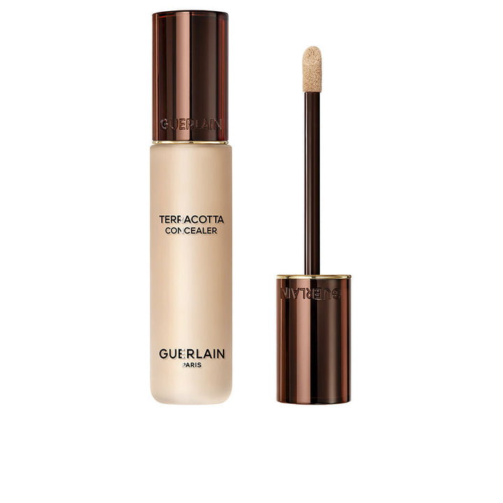 Guerlain Beige and dark brown liquid concealer in transparent cylindrical bottle with metallic cap and wand.