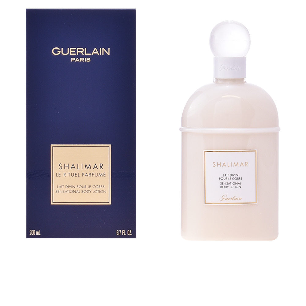 Navy blue and beige rectangular box beside glossy rounded bottle with spherical cap and gold-bordered label, Guerlain