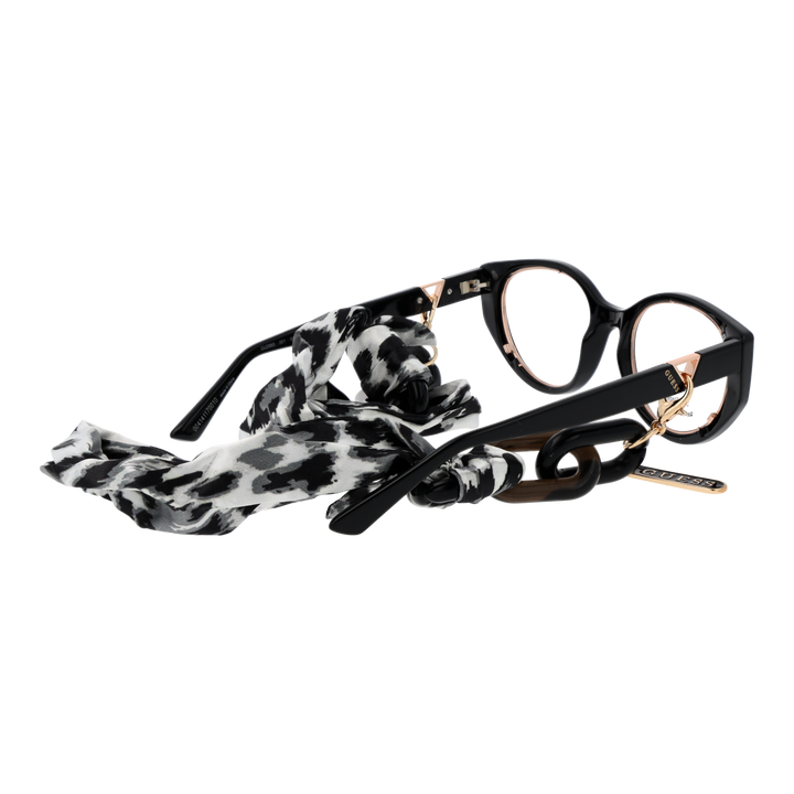 Black and gold cat-eye eyeglasses with thin metal temples and patterned fabric strap laid on white background