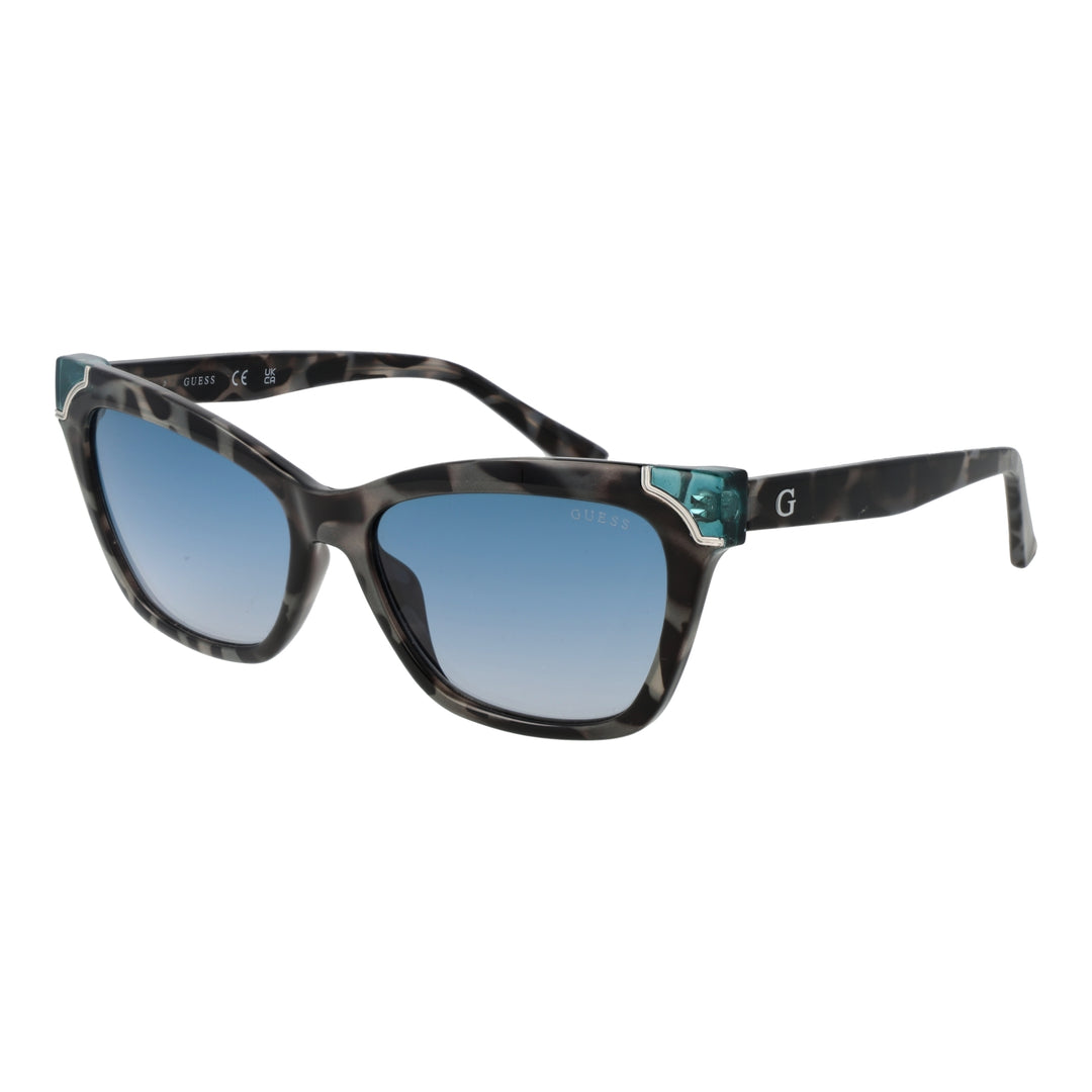 Guess tortoise cat-eye sunglasses with blue gradient lenses and teal corner accents on a neutral background
