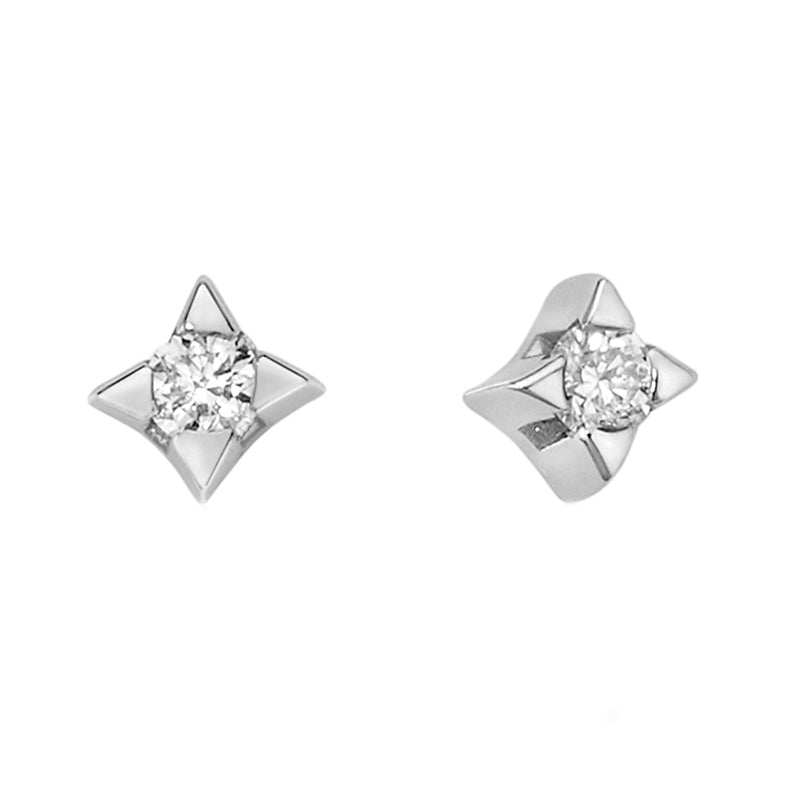 Pair of platinum stud earrings with central diamonds in four-point star settings on polished metal background